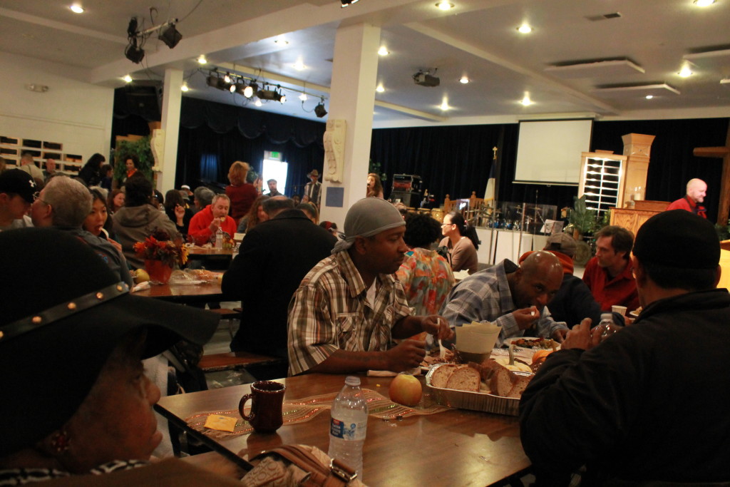 View of the inside of Celebration Tabernacle, with community members eating together at long tables.